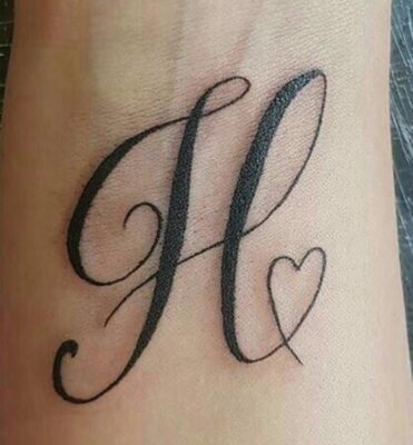 Hình xăm chữ cái trang trí cổ tay phong cách blackwork, độ chi tiết cao, ảnh HD.