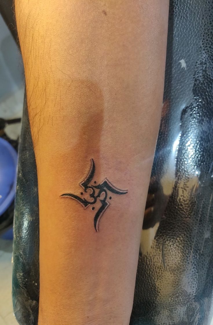 Hình xăm ký hiệu trên cánh tay, phong cách blackwork, chi tiết rõ nét, độ phân giải HD.