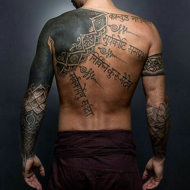 Hình xăm chữ Phạn ấn tượng và đầy đủ trên lưng Hình xăm chữ và hoa văn tribal trên lưng và tay, phong cách blackwork, chi tiết, ảnh HD.