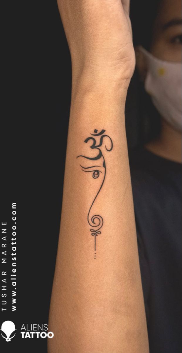 Hình xăm chữ Phạn đơn giản trên tay Hình xăm ký hiệu Om trên cánh tay, phong cách blackwork, chi tiết rõ nét, độ phân giải HD.