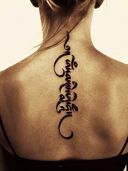 Hình xăm chữ Phạn mang ý nghĩa sâu sắc trên lưng Hình xăm chữ dọc lưng, phong cách blackwork, chi tiết rõ nét, ảnh độ phân giải cao.