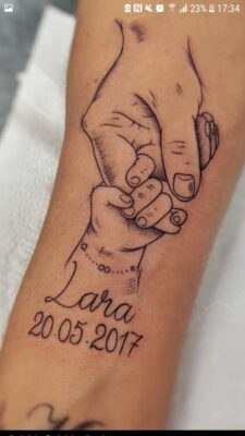 Hình xăm tay nắm tay, phong cách blackwork, vị trí cánh tay, chi tiết rõ nét.