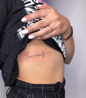 Hình xăm chữ "Serendipity" trên sườn, phong cách tối giản, độ chi tiết cao, ảnh HD.