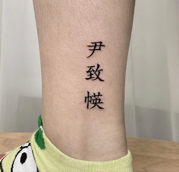 Hình xăm chữ Hán ở chân, phong cách blackwork, độ phân giải HD.