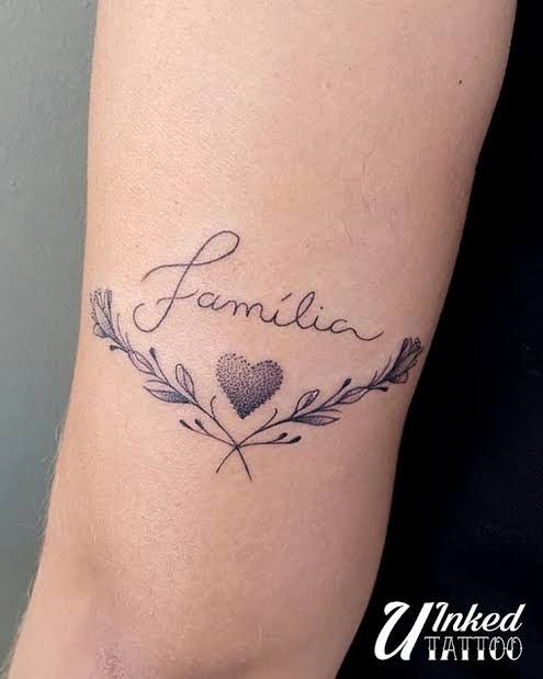 Mẫu xăm lý tưởng cho người yêu gia đình Hình xăm chữ "família" với họa tiết trái tim và lá trên tay, phong cách blackwork, ảnh HD.