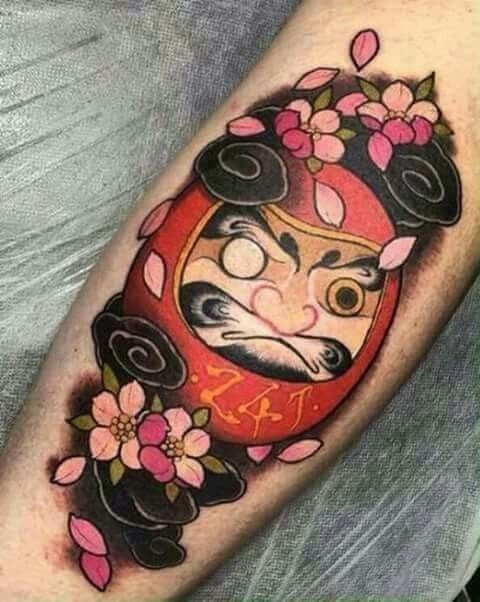 Hình xăm Daruma mặt tròn hài hước kết hợp cánh hoa anh đào vô cùng hấp dẫn Hình xăm búp bê Daruma trên cánh tay, phong cách màu sắc, chi tiết cao, độ phân giải HD.