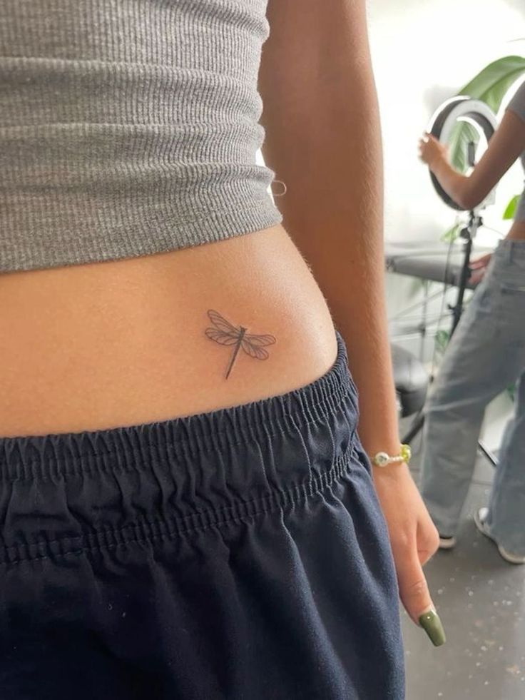 mẫu xăm eo chuồn chuồn nhỏ Hình xăm chuồn chuồn mini ở hông, phong cách blackwork, độ chi tiết cao, ảnh chất lượng HD.