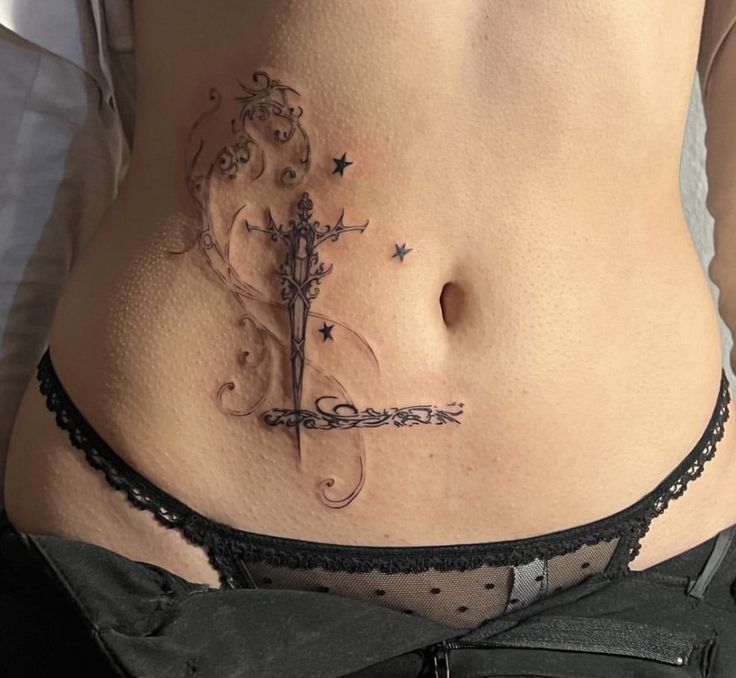 Mẫu xăm eo quyến rũ Hình xăm kiếm phong cách blackwork trên bụng, chi tiết tinh xảo, độ phân giải HD.
