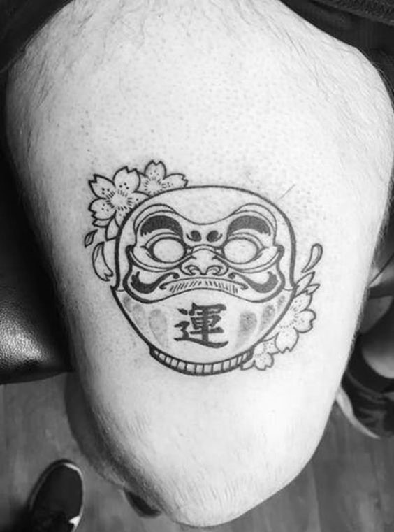 Mẫu xăm Daruma cùng hoa anh đào cầu mong may mắn Hình xăm Daruma phong cách blackwork trên đùi, chi tiết sắc nét, ảnh độ phân giải HD.