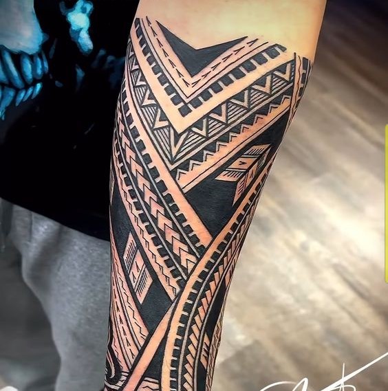 Hình xăm tribal trên cánh tay, phong cách blackwork chi tiết, ảnh chất lượng cao.