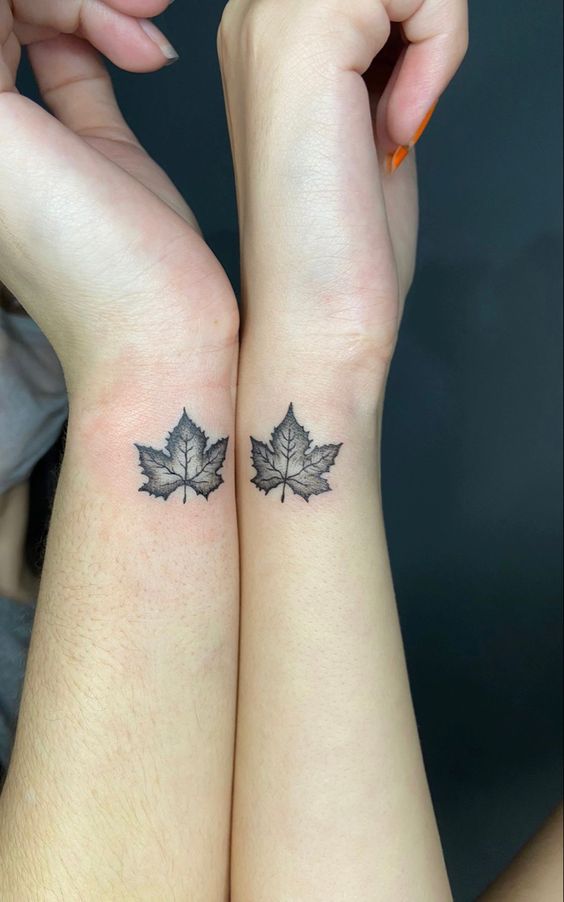 hình xăm đôi lá phong cho cặp bạn thân Hình xăm lá phong mini trên cổ tay, phong cách blackwork, chi tiết rõ nét, ảnh độ phân giải cao.