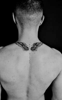 Hình xăm đôi cánh trên gáy, phong cách blackwork, chi tiết rõ nét, ảnh HD.