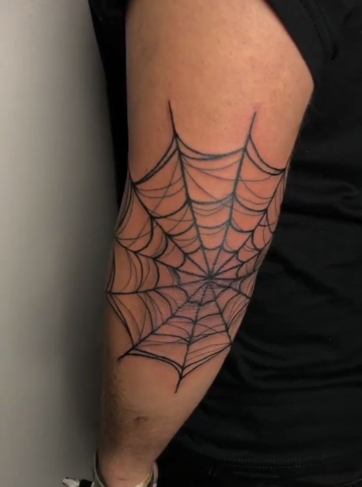 Hình xăm mạng nhện trên khuỷu tay, phong cách blackwork, chi tiết rõ nét, ảnh HD.