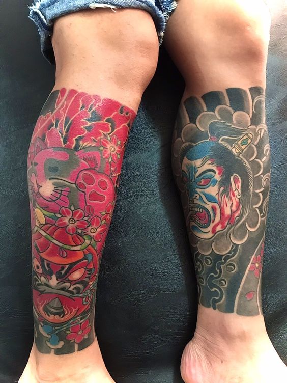 mẫu xăm mặt quỷ đối diện và daruma hai bên bắp chân Hình xăm phong cách Nhật Bản, màu sắc rực rỡ, trên bắp chân; độ chi tiết cao, ảnh HD.