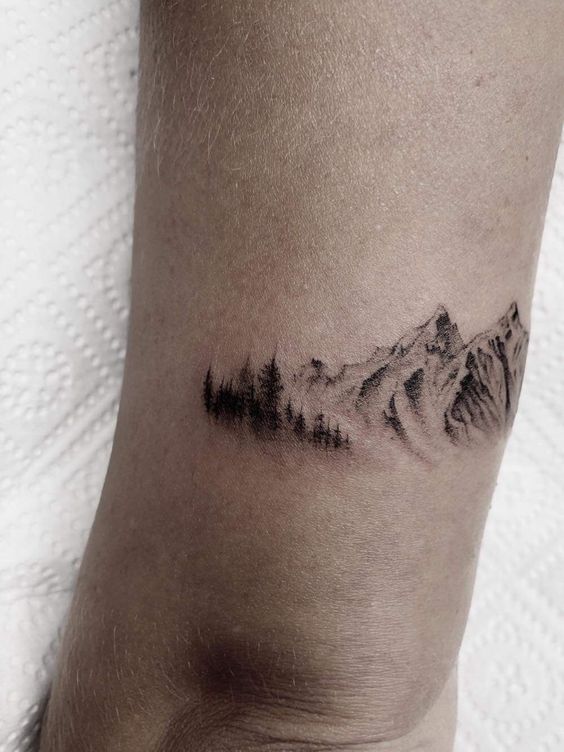 Hình xăm phong cảnh núi và rừng trên cổ tay, phong cách blackwork, chi tiết rõ nét, độ phân giải HD.