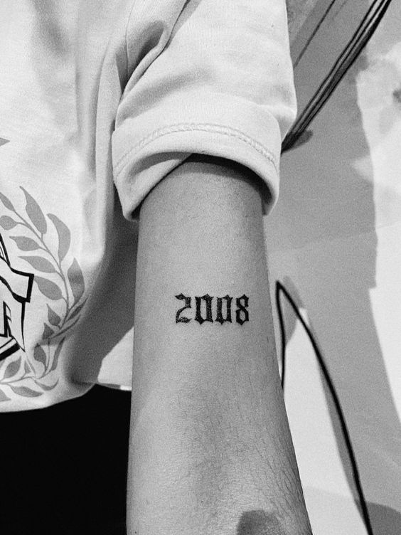 Hình xăm số "2008" trên cánh tay, phong cách blackwork, chi tiết rõ nét, ảnh đen trắng, độ phân giải HD.