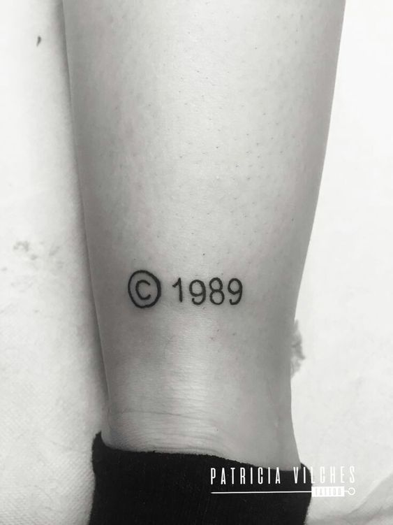 Hình xăm số "1989" phong cách blackwork trên chân, chi tiết đơn giản, ảnh đen trắng, độ phân giải HD.