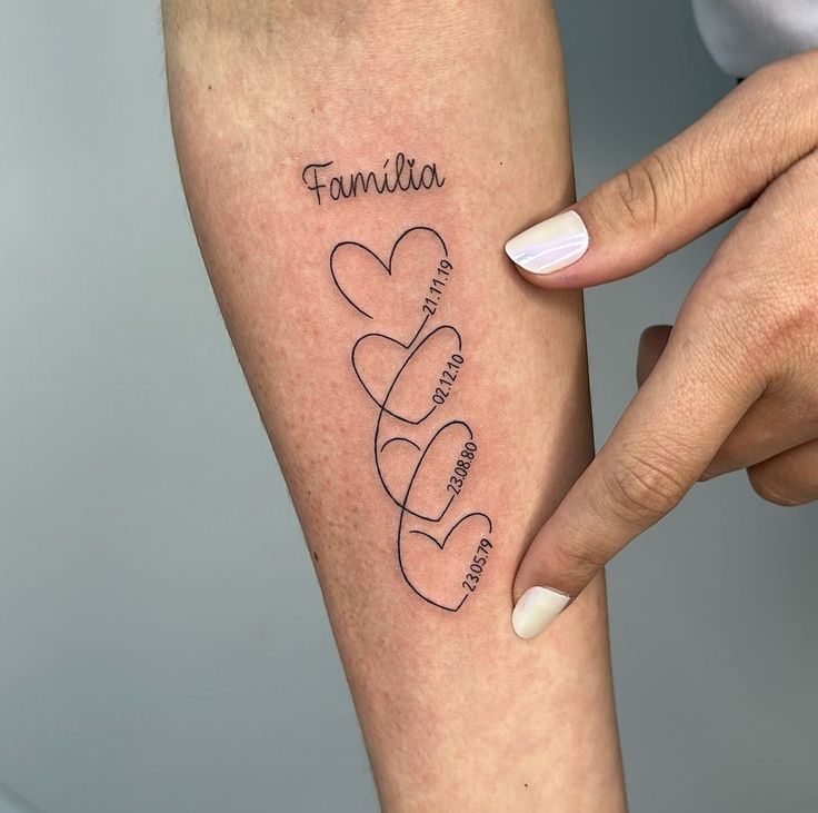 mẫu xăm năm sinh thành viên gia đình mini Hình xăm chữ "Familia" và trái tim dây, phong cách tối giản trên cánh tay; độ phân giải HD.