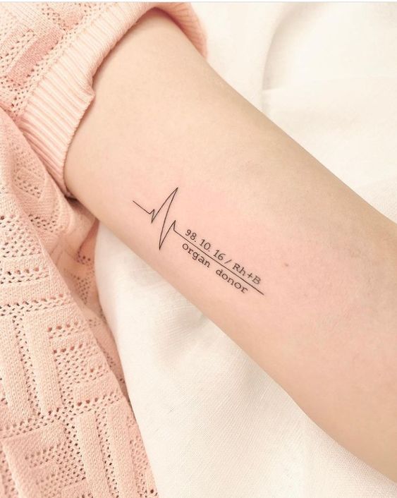 Hình xăm nhịp tim tối giản trên cánh tay, phong cách blackwork, độ phân giải HD.