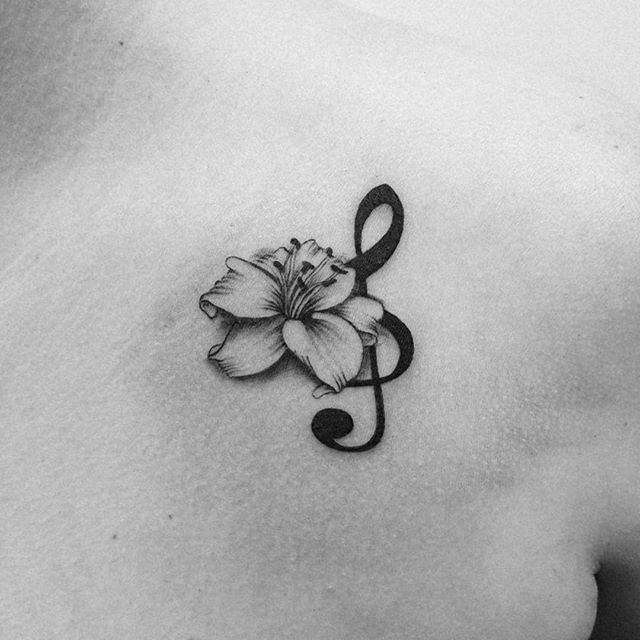 Hình xăm nốt nhạc và hoa ở vai, phong cách blackwork, chi tiết tinh tế, độ phân giải HD.