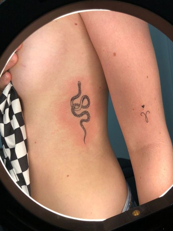 Hình xăm rắn mini phong cách blackwork trên sườn, chi tiết rõ nét, ảnh độ phân giải HD.
