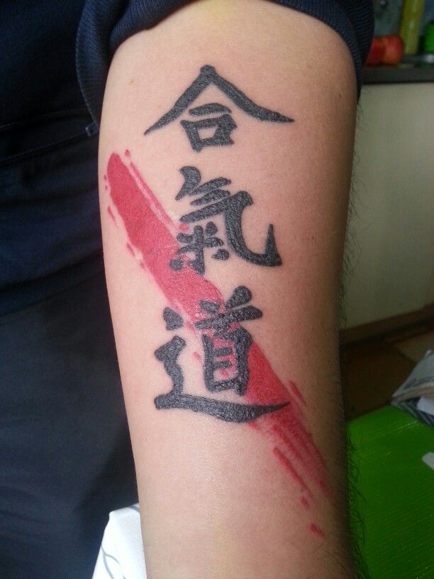Hình xăm chữ Nhật trên cánh tay, phong cách blackwork pha màu đỏ, chi tiết rõ nét, độ phân giải HD.