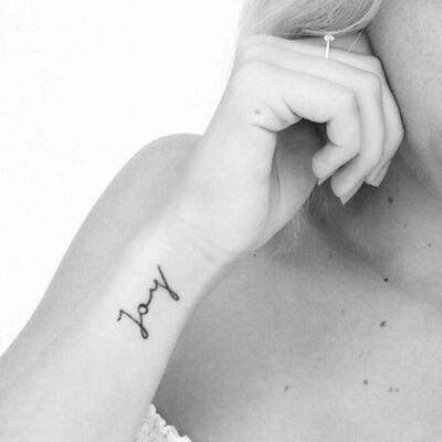 Mẫu xăm tên độc đáo trên cổ tay Hình xăm chữ "joy" trên cổ tay, phong cách tối giản, ảnh chất lượng HD, chi tiết tinh tế.