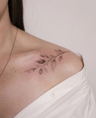 Hình xăm nhánh lá tinh tế trên vai, phong cách blackwork, độ chi tiết cao, ảnh HD.
