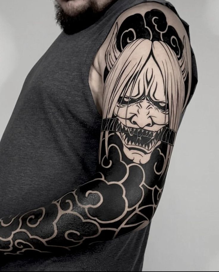 Hình xăm mặt quỷ phong cách blackwork trên cánh tay, chi tiết rõ nét, độ phân giải HD.