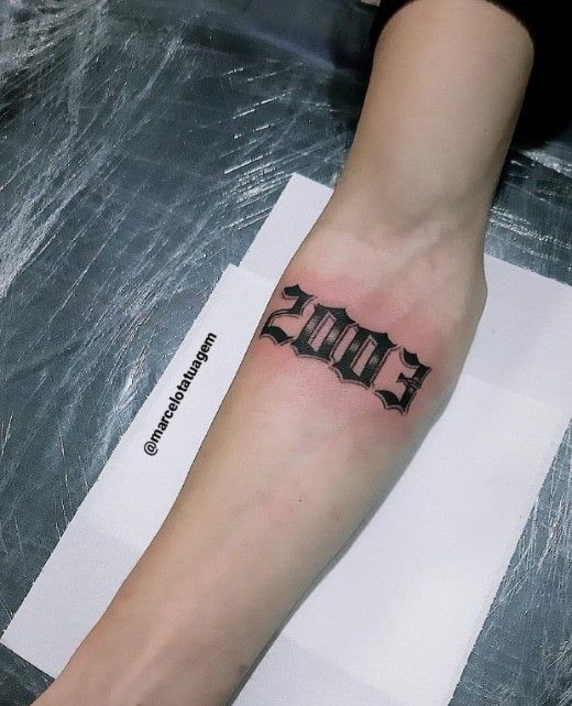 Nghệ thuật xăm năm sinh trên cẳng tay Hình xăm chữ số 2003 trên cánh tay, phong cách blackwork, chi tiết rõ nét. Ảnh HD.
