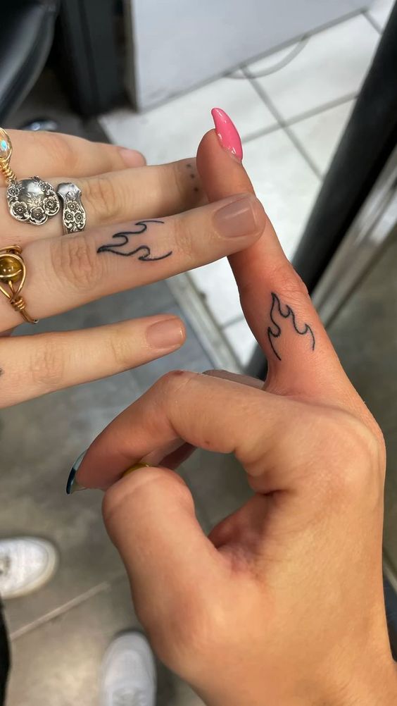 Ngọn lửa tỏa năng lượng sống tích cực Hình xăm ngọn lửa mini trên ngón tay, phong cách blackwork đơn giản, độ chi tiết cao, ảnh HD.