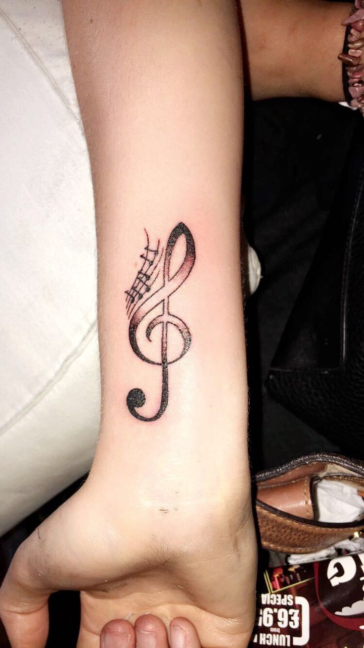 Hình xăm khóa Sol trên cổ tay, phong cách blackwork, chi tiết rõ nét, độ phân giải HD.