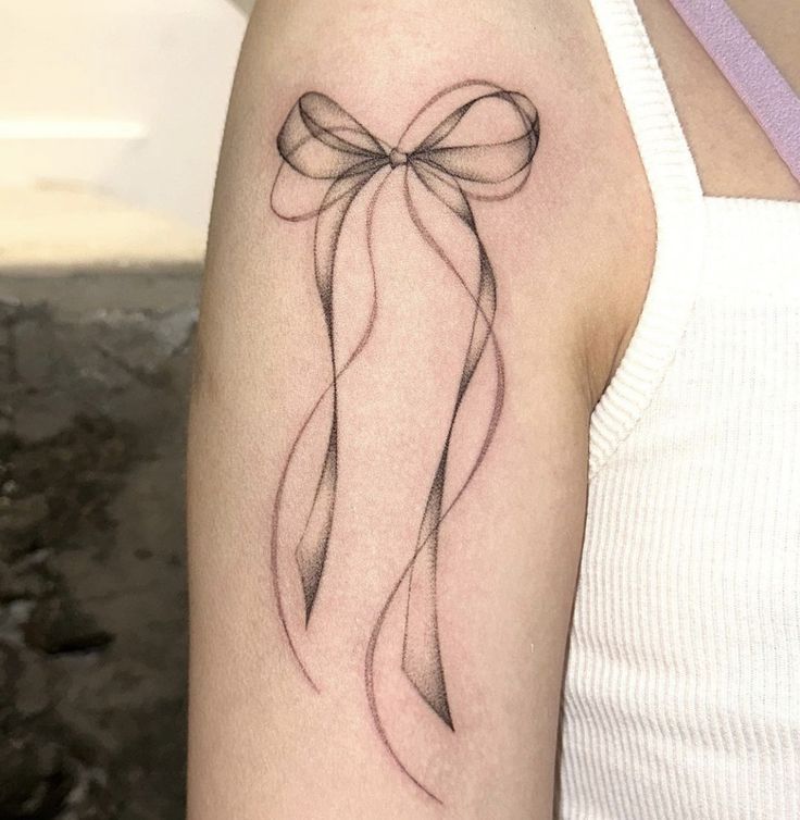 Nút thắt xinh xắn cho phái nữ Hình xăm nơ phong cách blackwork trên bắp tay, chi tiết tinh tế, ảnh chất lượng HD.