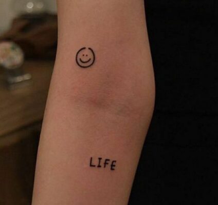 Hình xăm mini mặt cười và chữ "LIFE" trên tay, phong cách đơn giản, độ phân giải HD.