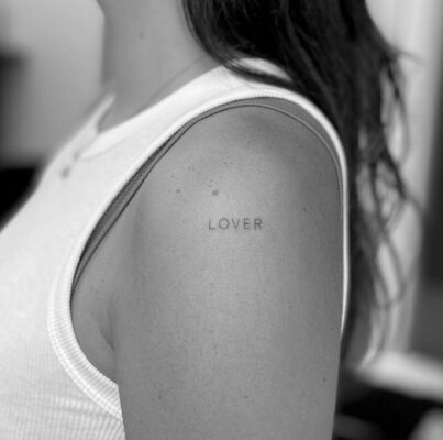 phong cách với mẫu xăm ý nghĩa trên bắp tay Hình xăm chữ "Lover" trên vai, phong cách tối giản, ảnh đen trắng, độ phân giải HD.