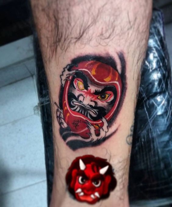 phong cách xăm daruma và mặt quỷ phản diện nhau Hình xăm mặt nạ Nhật Bản trên chân, phong cách màu sắc, chi tiết rõ nét, độ phân giải HD.