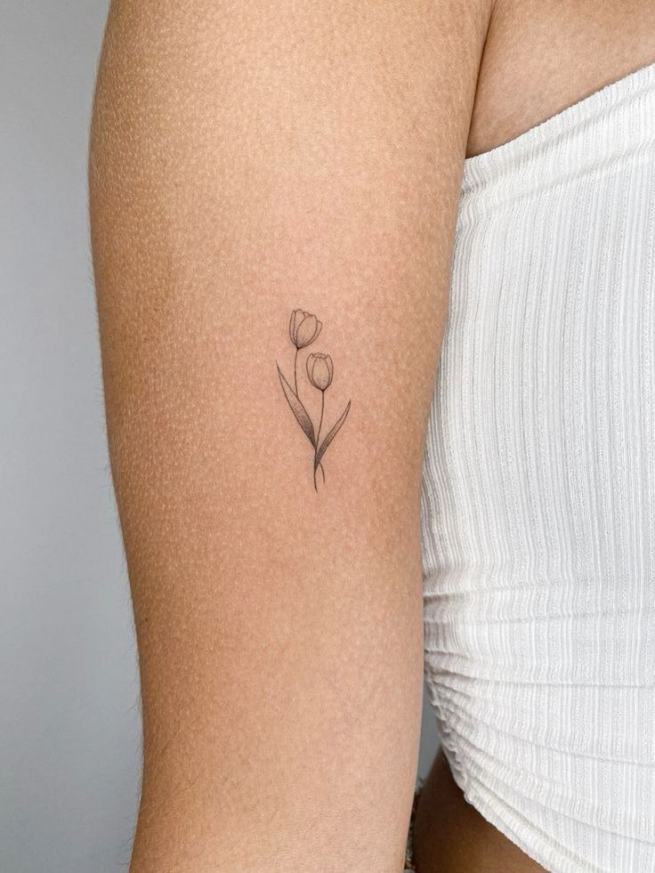 Hình xăm hoa tulip mini trên cánh tay, phong cách blackwork, chi tiết rõ nét, độ phân giải HD.