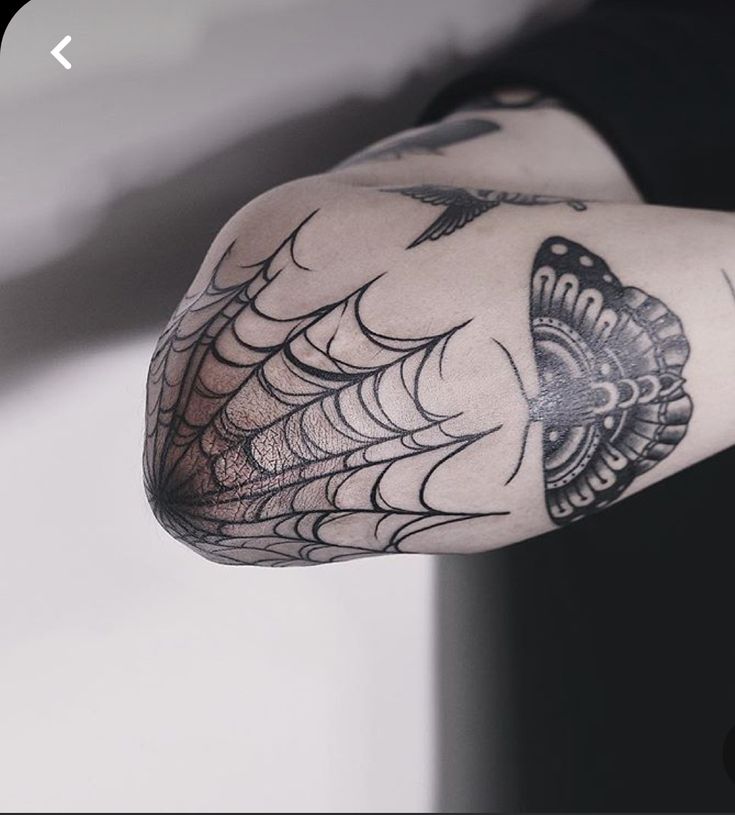 Hình xăm mạng nhện và bướm trên khuỷu tay, phong cách blackwork, độ chi tiết cao, ảnh HD.