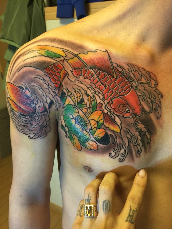 Tattoo cá chép và hoa sen trải dài từ ngực đến vai Hình xăm cá chép màu sắc trên ngực, phong cách truyền thống, chi tiết rõ nét, độ phân giải HD.