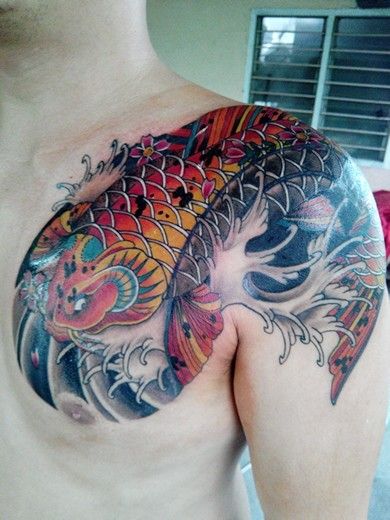 Tattoo cá chép rực rỡ với nhiều màu sắc độc đáo Hình xăm cá chép màu sắc trên ngực, phong cách truyền thống, độ chi tiết cao, ảnh chất lượng HD.