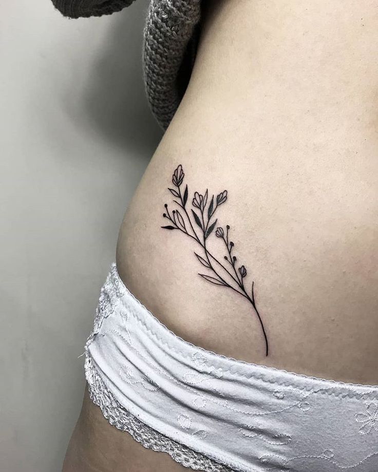 Hình xăm cỏ lau nhỏ nhắn Hình xăm hoa mini trên hông, phong cách blackwork, chi tiết rõ ràng, độ phân giải HD.