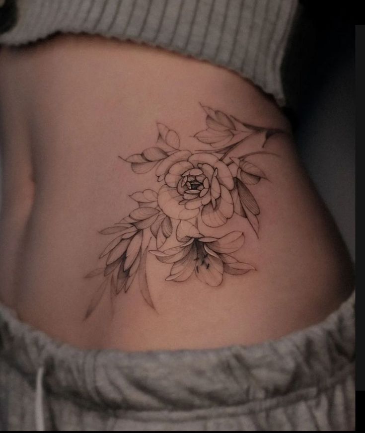Tattoo cuốn hút ở eo cho khách Hình xăm hoa trên eo phong cách blackwork, chi tiết tinh tế, độ phân giải HD.