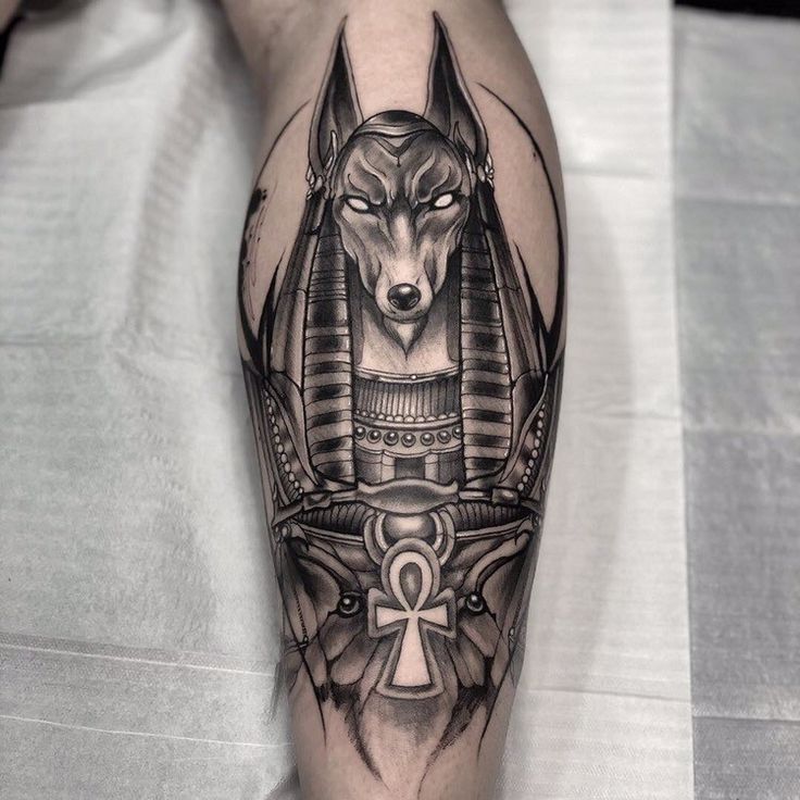 Hình xăm Anubis cổ điển, blackwork trên bắp chân, chi tiết sắc nét, độ phân giải HD.