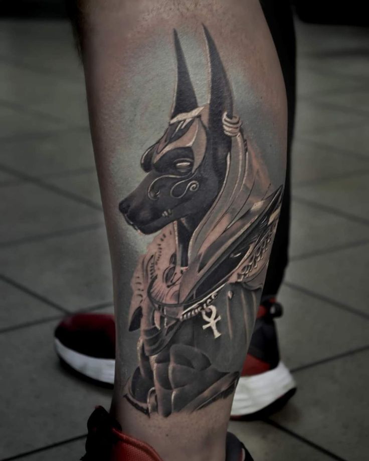 Hình xăm Anubis cổ điển trên chân, phong cách blackwork chi tiết, độ phân giải HD.
