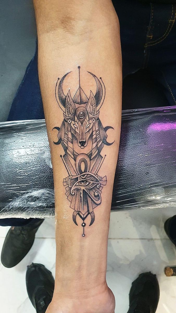 Hình xăm Anubis đen trắng trên cẳng tay, phong cách blackwork chi tiết, độ phân giải HD.