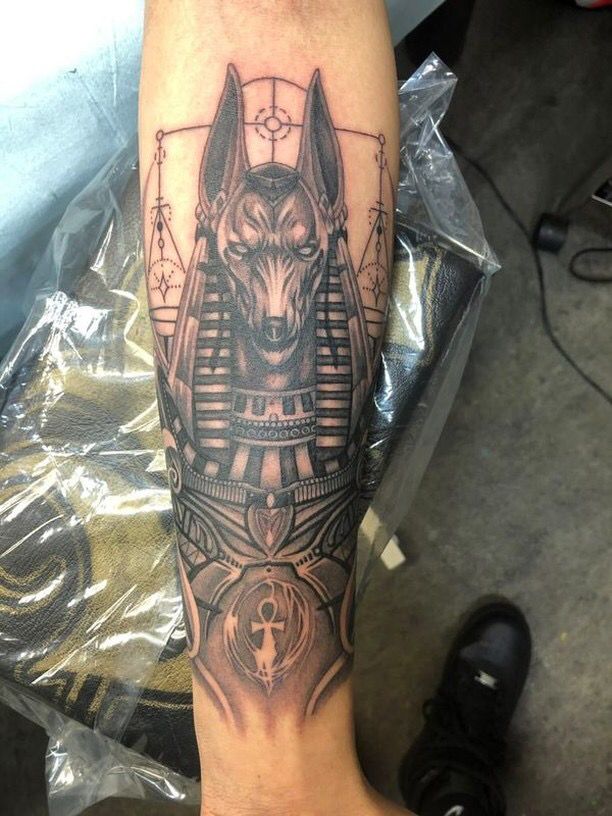 Hình xăm thần Anubis phong cách blackwork trên cánh tay, chi tiết tinh xảo, độ phân giải HD.