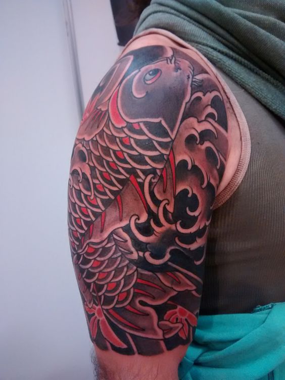 Tattoo cá chép đen kết hợp họa tiết lá cây và nước Hình xăm cá chép phong cách cổ điển trên bắp tay, chi tiết rõ nét, độ phân giải HD.