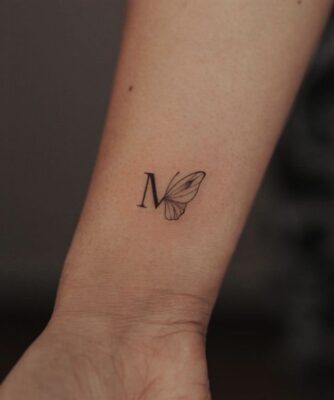 tattoo chữ cái tên viết tắt trên cẳng tay Hình xăm chữ và cánh bướm mini trên cổ tay, phong cách blackwork, ảnh HD.