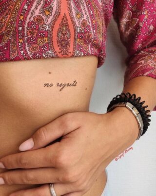 Hình xăm chữ "no regrets" trên sườn, phong cách tối giản, ảnh HD.