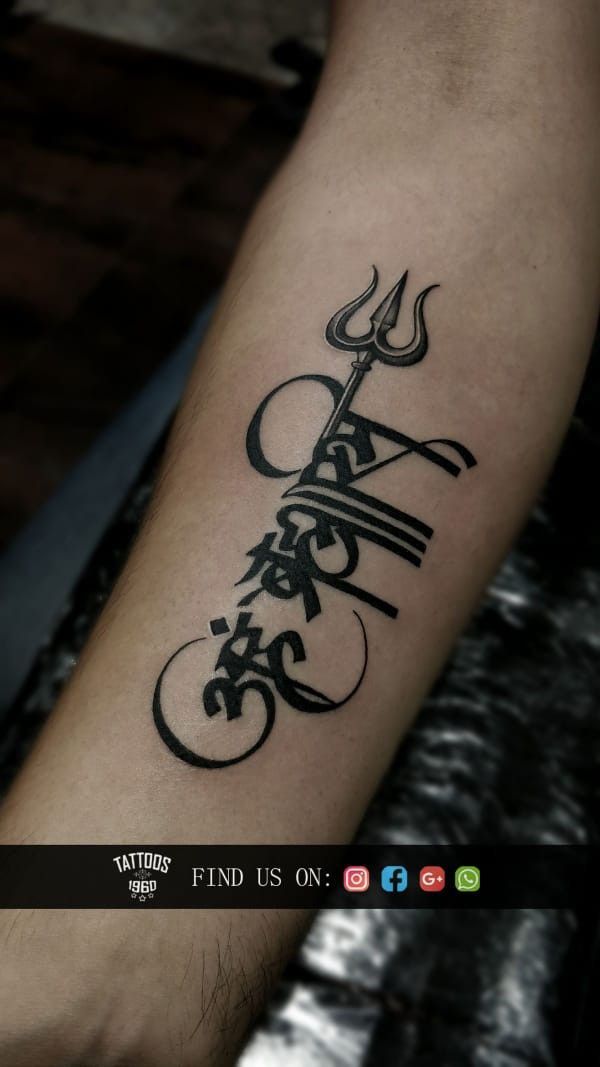 Tattoo chữ Phạn ấn tượng trên cẳng tay Hình xăm chữ và biểu tượng Trishul trên cánh tay, phong cách blackwork, độ chi tiết cao, ảnh HD.